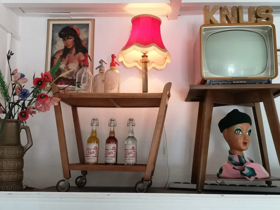 Vintage hoekje met KNUS-letters, oude televisie en flesjes