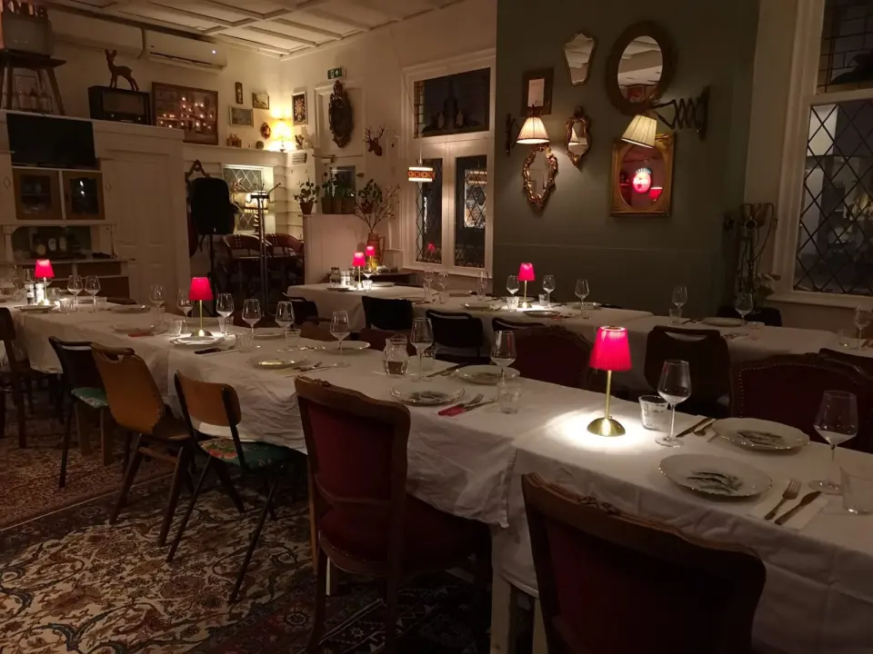 Feestelijk gedekte lange tafels met rode lampjes bij Knus Bussum